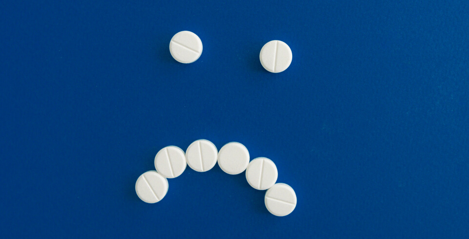 White abortion bills arranged into a sad 'smiley' face, on vivid blue background