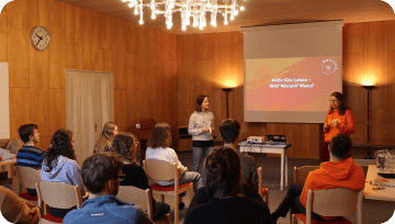 A photo of two ProLife Europe members giving a pro-life talk to a seated audience